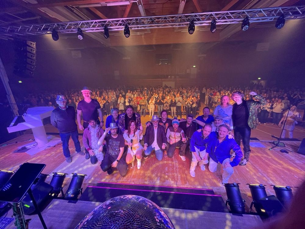 A picture of me with the whole cast and crew of The Magic Of ABBA Show standing on stage, with an audience of 800 behind them.
