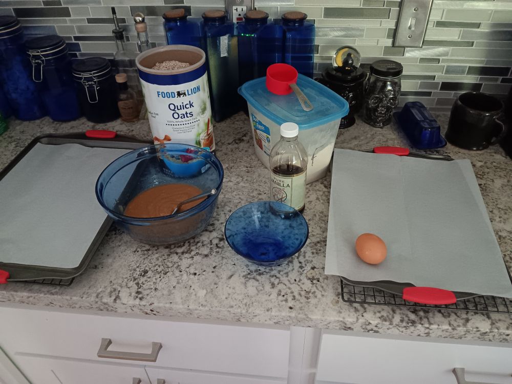 Ingredients laid out for oatmeal cookies, butter and sugar already in the bowl.
