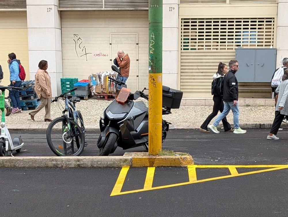Photo of a grey BMW CE 04 parked up on a street in Lisbon