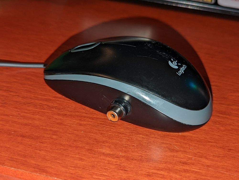 Picture of a Logitech computer mouse which has been modified to have an RCA video cable input, with the reasons for this modification not being clear.