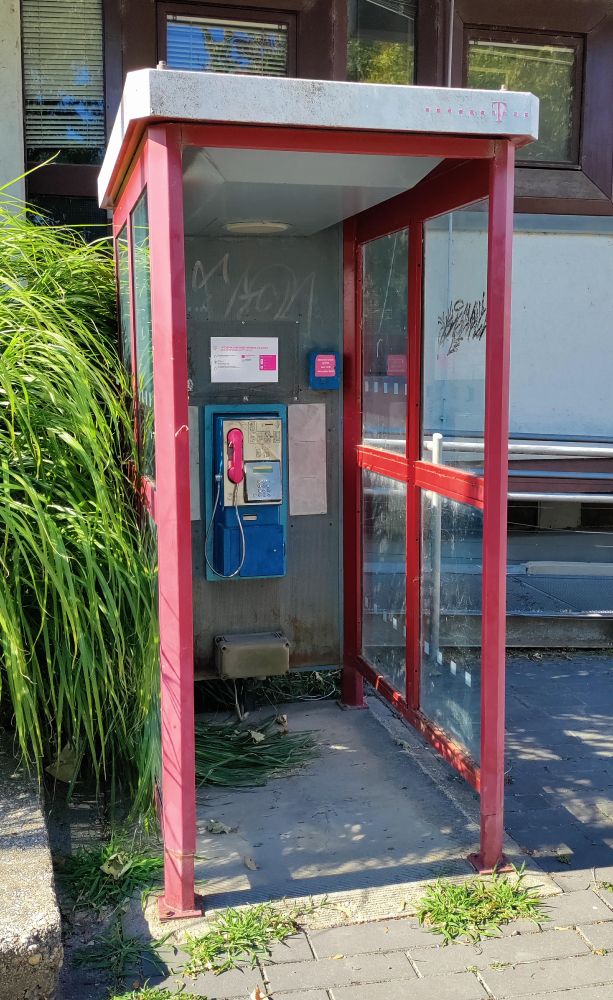 Telefonzelle mit telekomtypischen Magenta-Akzenten