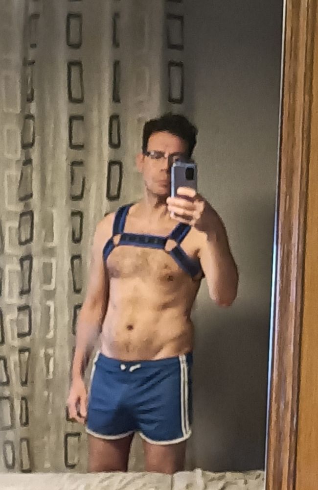 Chico con short deportivo azul y arnés con ribete azul