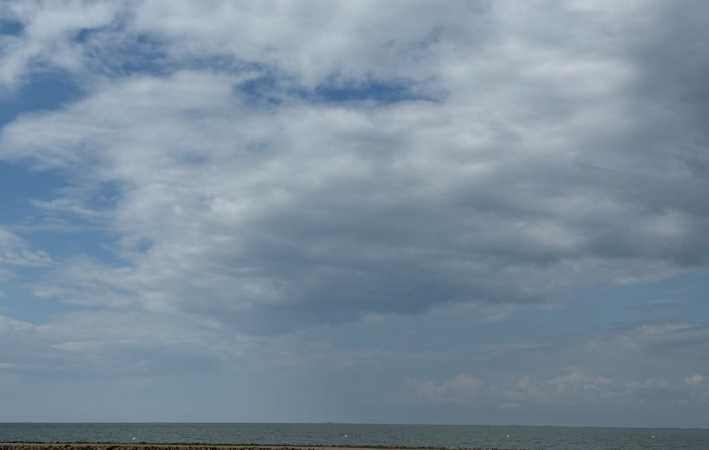 The North Sea under a cloudy sky. There are some waves, hardly any of the break in the open water.