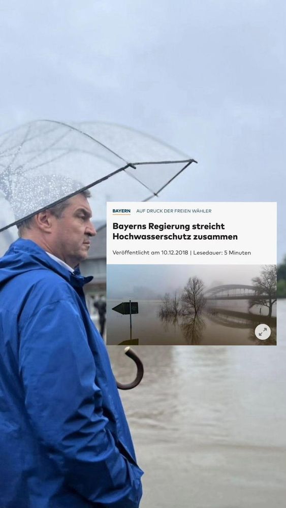 Bayerns Ministerpräsident Markus Söder steht in einem blauen Regenmantel und hält einen transparenten Regenschirm. Er blickt nachdenklich auf eine überflutete Straße, die von Hochwasser betroffen ist. Im Hintergrund sind ein graues Haus und einige Bäume zu sehen. Der Himmel ist bewölkt und regnerisch.
Auf seiner Augenhöhe ist in Blickrichtung der Screenshot eines Artikels aus der Welt, dieser lautet:
"Auf Druck der freien Wähler - Bayerns Regierung streicht Hochwasserschutz zusammen, veröffentlicht am 10.12.2018"