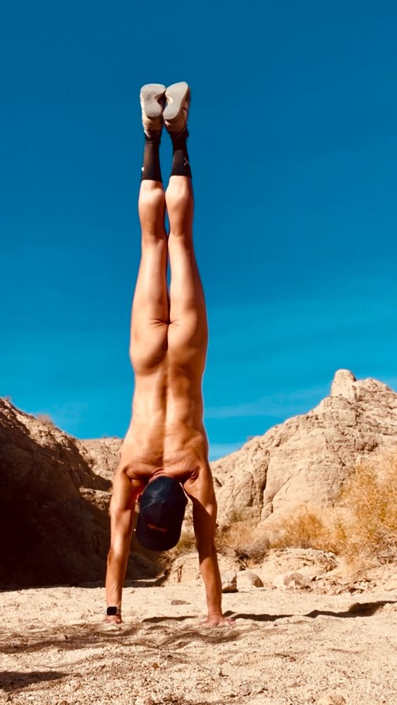 An image of a naked yogi doing a handstand in the high desert of Southern California.