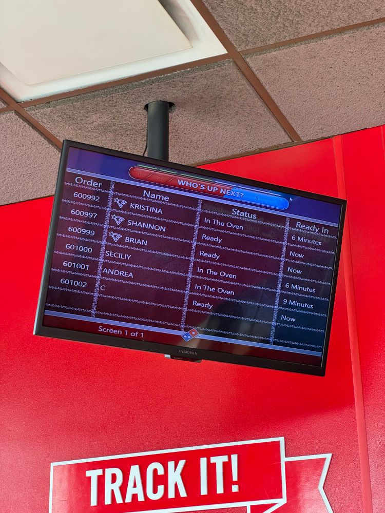 Tv skjerm med bestillinger hos Dominos. Bestillingen til "Secily" er 6 minutter unna å bli ferdig. 