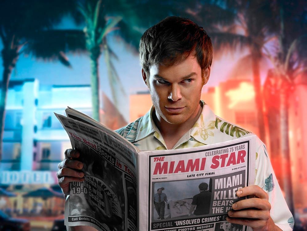 A man with a tropical shirt holding a news paper with palm trees on the background.