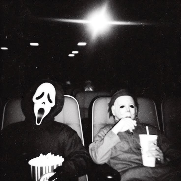 Black & white photo of someone wearing a Ghostface and Michael Myers costume at the movie theater.