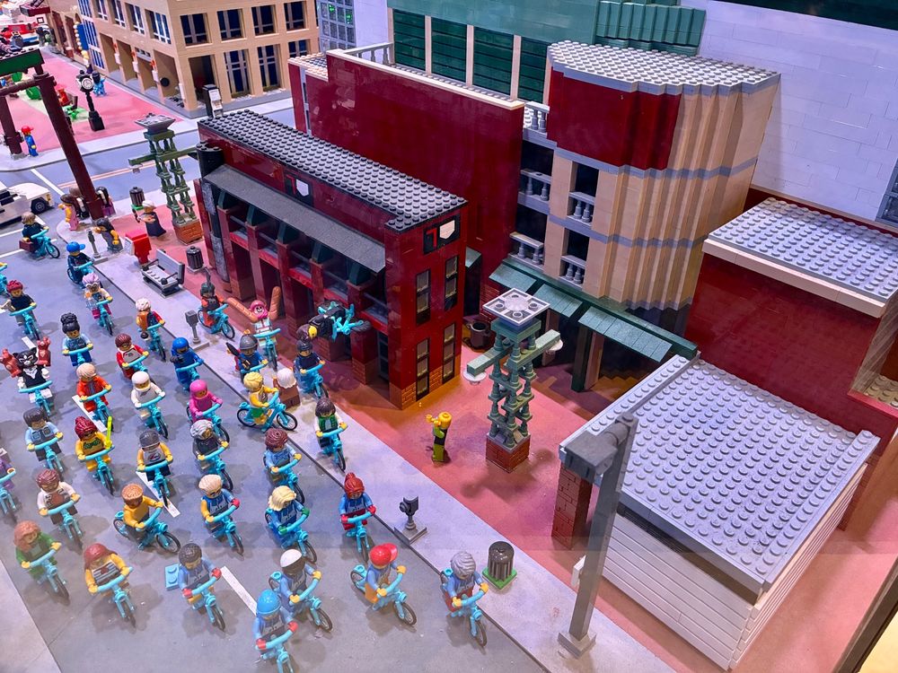 Lego figures of people of bicycles pedaling past a Lego version of Chase Field in downtown Phoenix.
