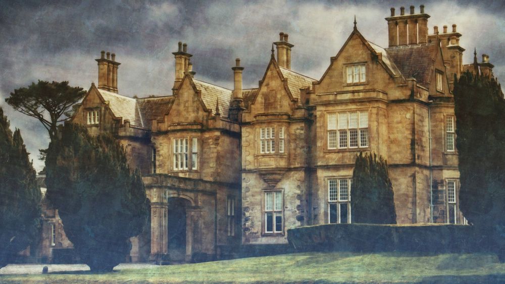 A gloomy mansion exterior in the daytime on an overcast day.