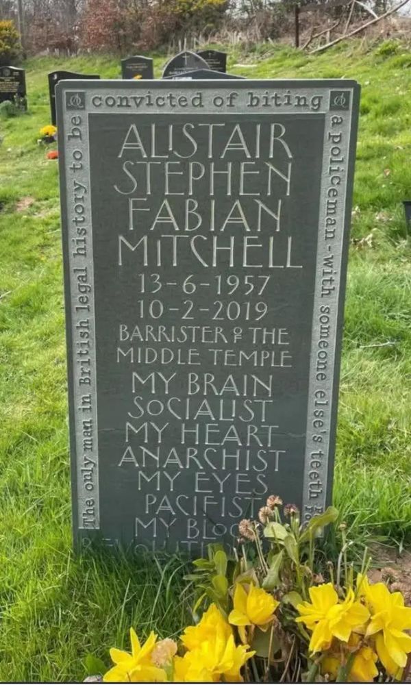 Inscription on the tomb stone of Alistair Stephen Fabian Mitchell 13-6-1957 to 10-2-2019

Barrister in 
Middle Temple
MY BRAIN 
SOCIALIST
MY HEART
ANARCHIST
MY EYES 
PACIFIST
MY BLOOD
EVOLUTI…(Rest Unreadable)

And important inscription around the edge of tombstone

The only man in British legal history to be convicted of biting a policeman - with someone else’s teeth