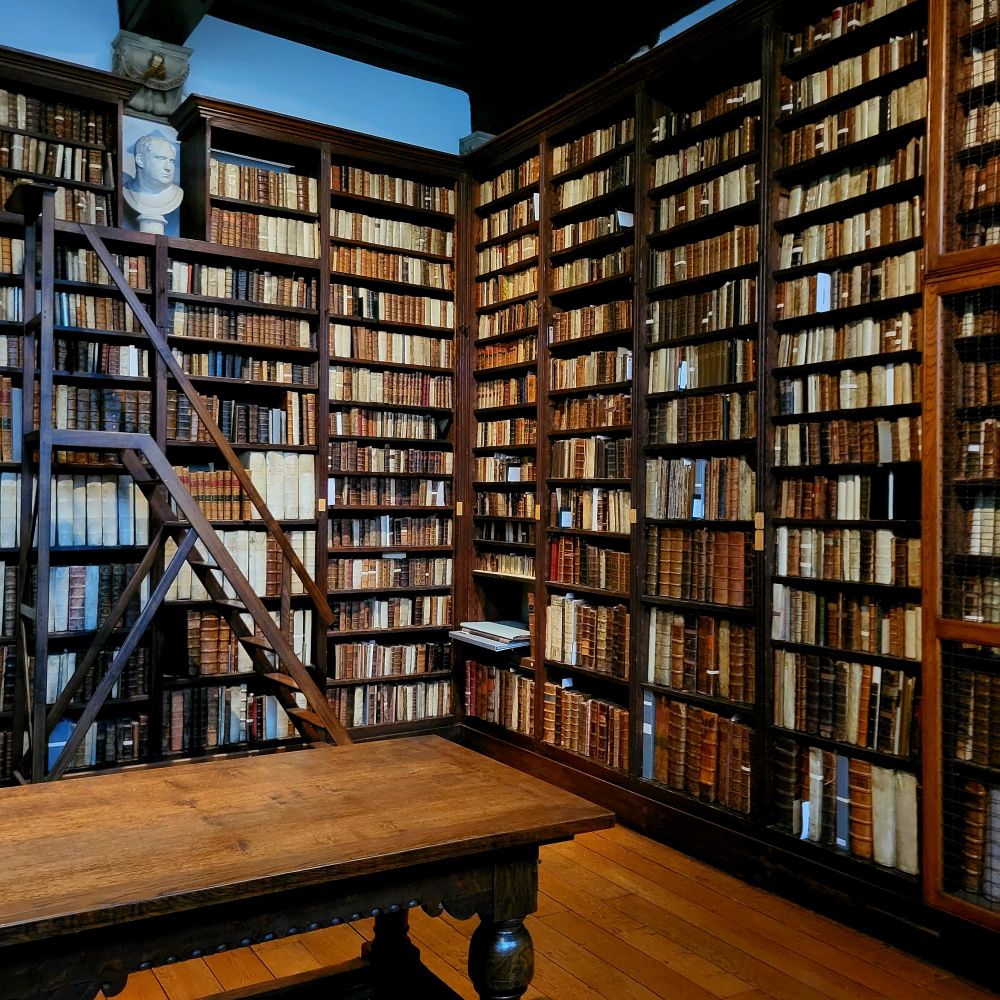 Photograph of lots of old books and a bust.