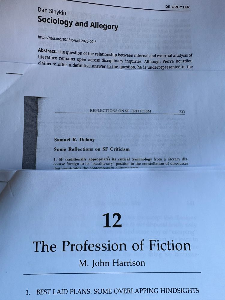 A pile of printed PDFs: M. John Harrison’s THE PROFESSION OF FICTION on Samuel Delany’s SOME REFLECTIONS ON SF CRITICISM on Dan Sinykin’s SOCIOLOGY AND ALLEGORY
