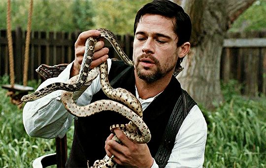 Brad Pitt as Jesse James holding a pair of snakes in "The Assassination of Jesse James By The Coward Robert Ford" .