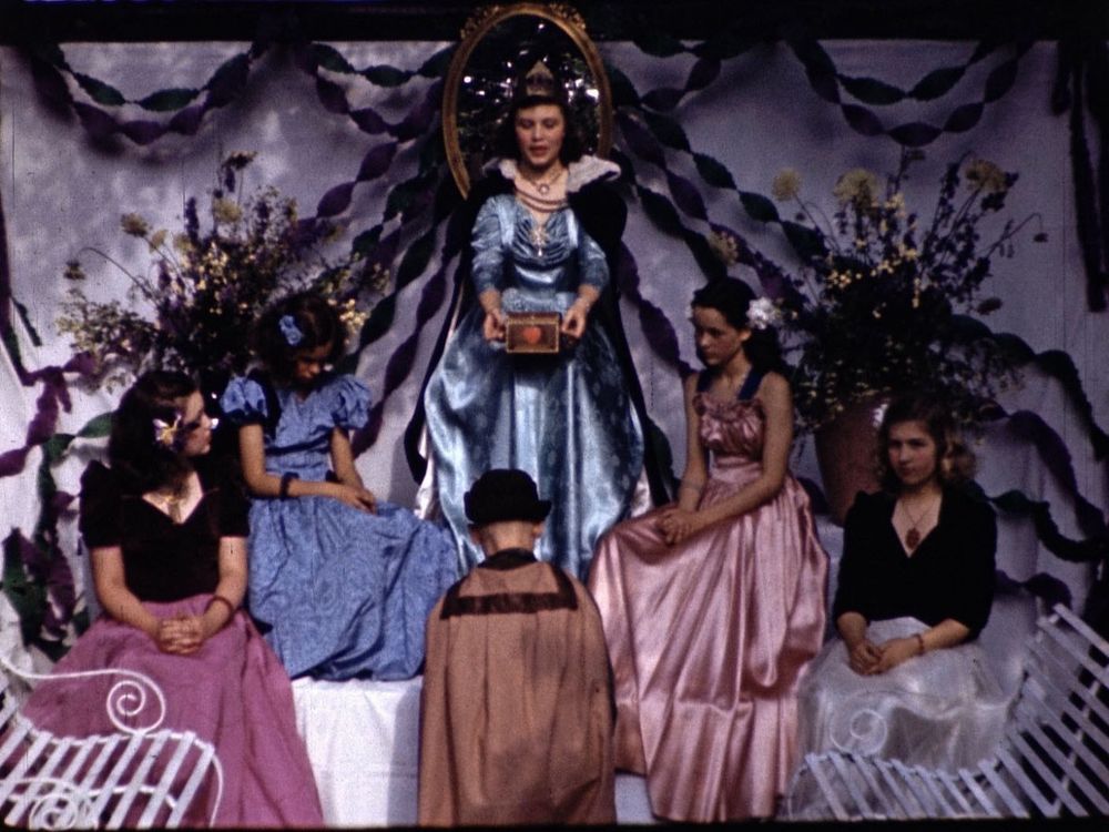 A 1945 version of Snow White with 5 women seated around a woman on a throne.