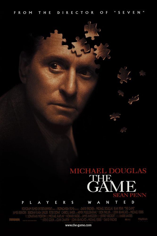 Movie poster for the film "the game" starring Michael Douglas. The poster is mostly black with Michael Douglas made of puzzle pieces that seem to be scattering away from him. The top of the poster says "from the director of"seven"."the tagline at the bottom seems to be "players wanted." 