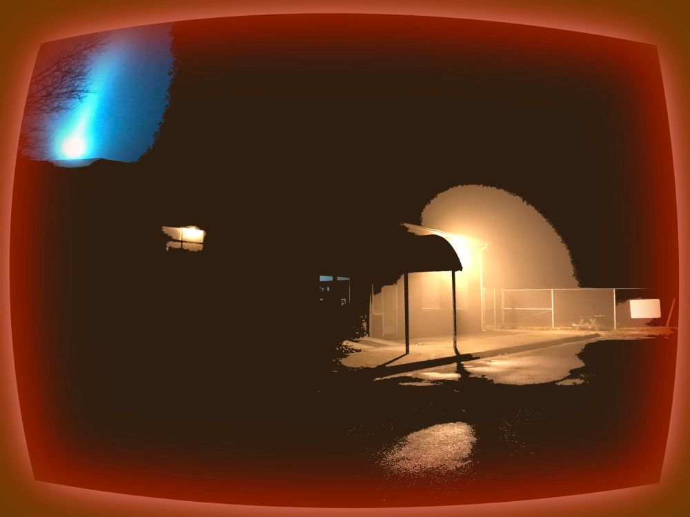 A photo of the original terminal building at the Raleigh County Memorial Airport (now a suite of offices), taken at night and filled in with digital ink to obscure most of the building details, casting only an edge of the roof, two windows, and an awning over the entryway—held up by two thin metal poles—into sharp relief. In the foreground the surface of an asphalt parking lot gleams with puddles of moisture lit by a bright light the a far corner of the building, behind the awning. A bubble of gold surrounds that lead and escapes the effects of the ink filled silhouette that characterizes most of the rest of the image. This bubble of light illuminates a chain-link fence in the background with some illegible signage posted on it. Two windows in the building glow with dim light of their own, one yellow and one blue, and a laser-bright beam of concentrated blue light is beaming upward or lancing downward in the upper left corner, appearing to strike or emanate from the roof of the building. This entire dark scene is warped into the shape of an old CRT TV screen, framed with a glowing reddish orange border.