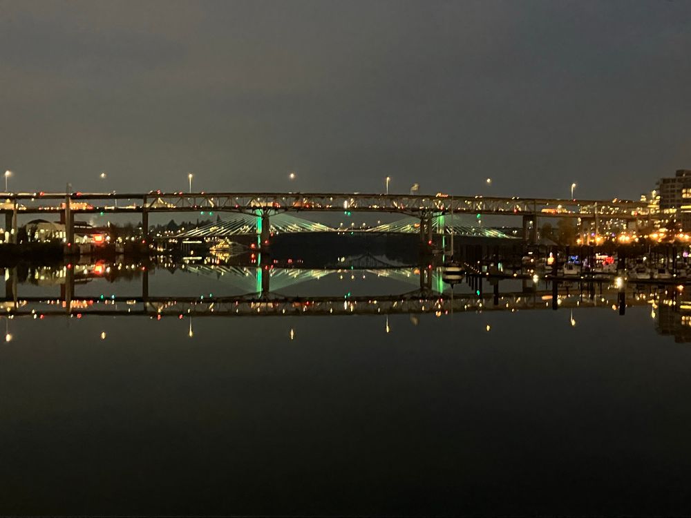 A view of I-5 above its own reflection in the Willamette River at night.