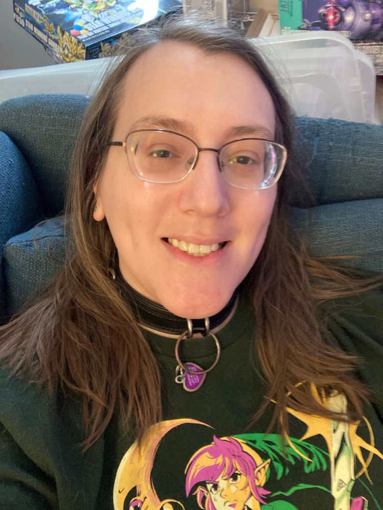 sleepyhead in 2025, laying on her couch and smiling at the camera