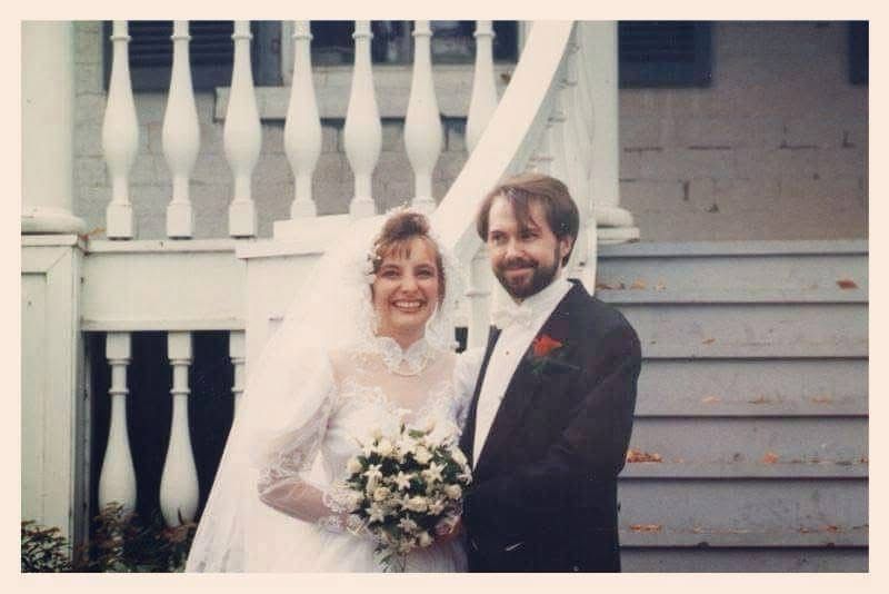 Sean and Teresa pose for a wedding picture outside Grant Hall at Queen’s University 35 years ago. Sean has an untidy mop of brown hair which has long since morphed into a close-cropped and grey bit of hair. Teresa looks pretty much the same