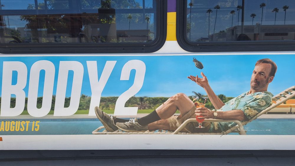 A staged photo that shows Bob Odenkirk leaning forward from his recliner chair by the pool