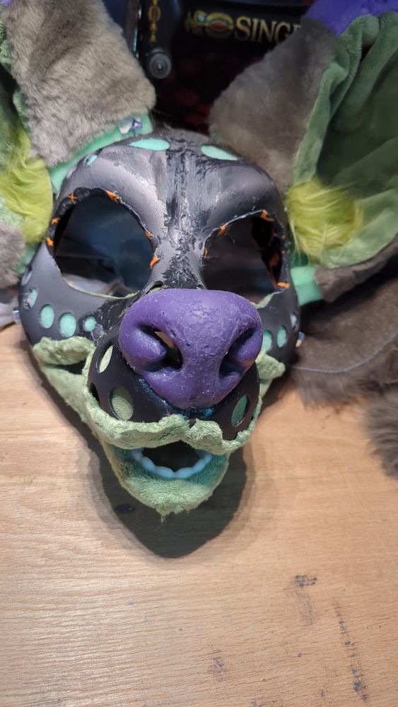 Shoes a fursuit head base with a purple silicone nose on it