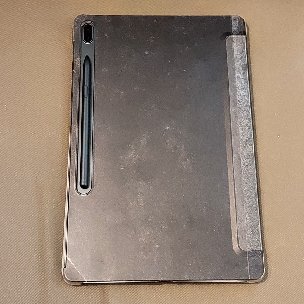 Samsung tablet with protection cover that looks like a spell book showing the back where the S-Pen is attached