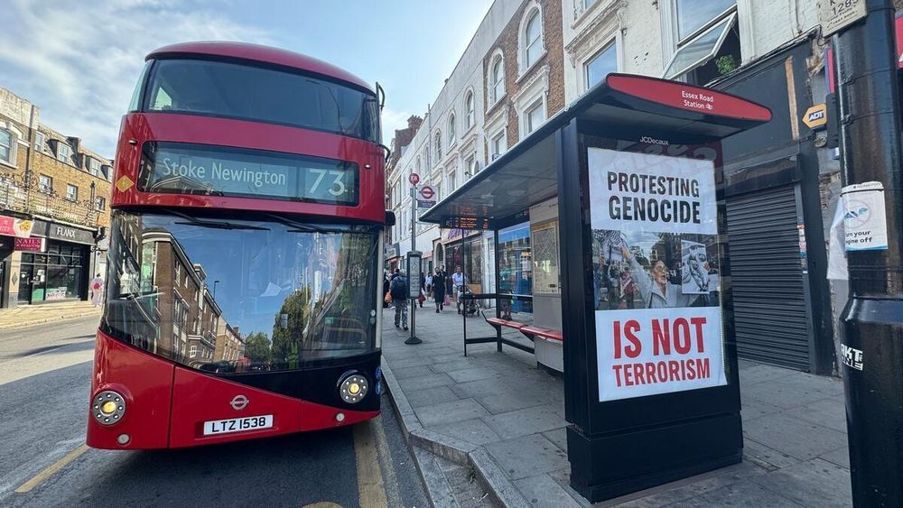 No 73 London bus in front of 'protesting genocide is not terrorism' guerilla bus stop ad