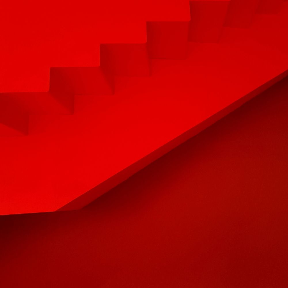 Looking directly at a red wall at The Lowry theatre and exhibition venue today. There is a horizontal lighter red section above that is part of a stairway 