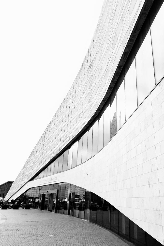 A black and white photo of the side of the Museum of Liverpool today
It is a angular glass and white brick building that creates a triangular shape at one side