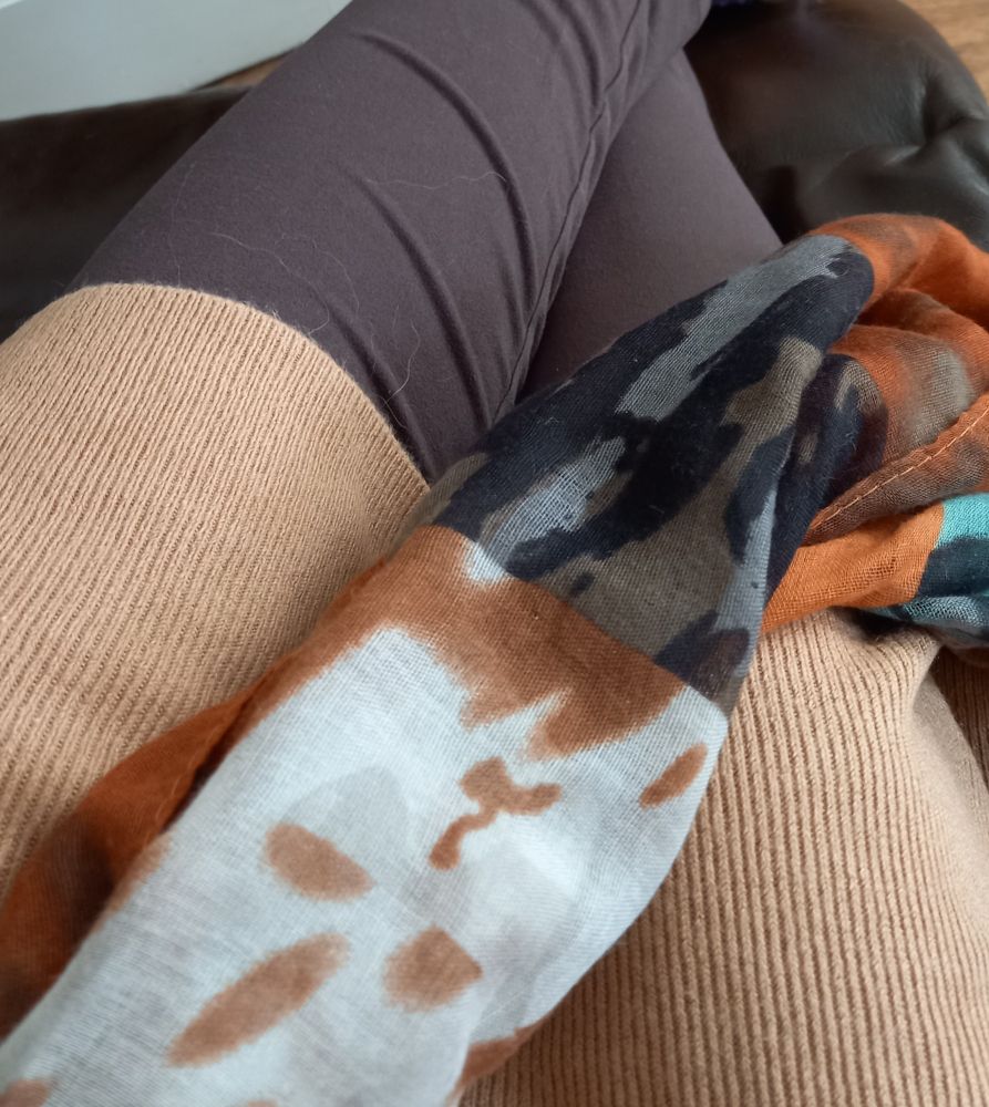 A section of a camel coloured dress next to 
dark brown leggings and a toning scarf with beige, dark & light brown, rust, and black print.