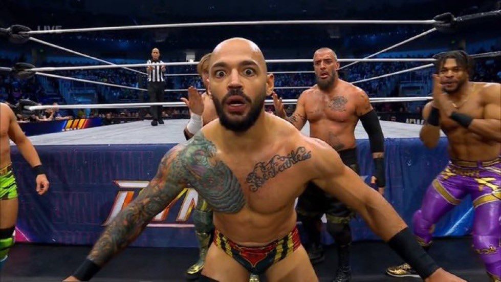Ricochet with a flabbergasted expression while Speedball, Ospreay, Briscoe, and Knight all surround him