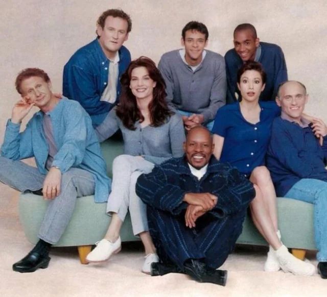 The original cast of Star Trek: Deep Space Nine, out of costume and make up and in casual clothing that would have been era appropriate for the mid 1990s. Pictured are actors Colm Meaney, Alexander Siddig, Cirroc Lofton, Rene Auberjonois, Terry Farrell, Nana Visitor, Armin Shimerman, and Avery Brooks.