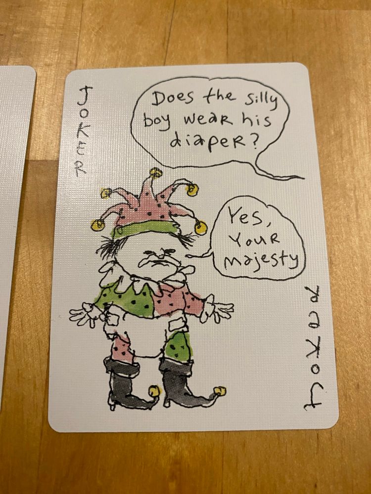 Joker. Out of frame king says “does the silly boy wear his diaper?” Jester wearing a diaper replies “Yes your majesty”