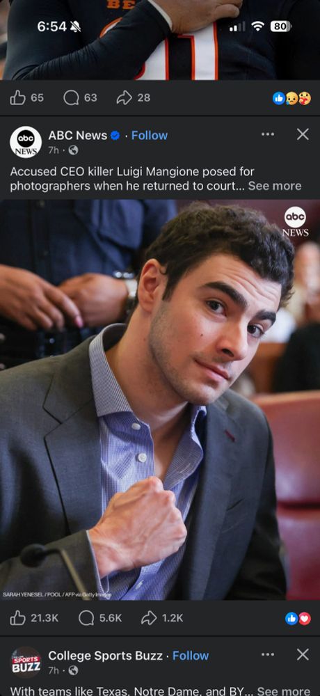 A picture of Luigin Mangione on FB, posing in court in a suit and button down shirt, looking directly at the camera