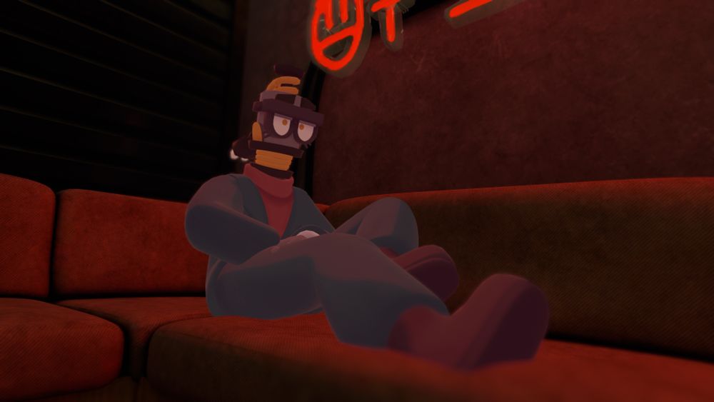 Circa relaxing on a red couch, one leg stretched forward while the other is bent slightly upward. She’s staring somewhat off into the distance.