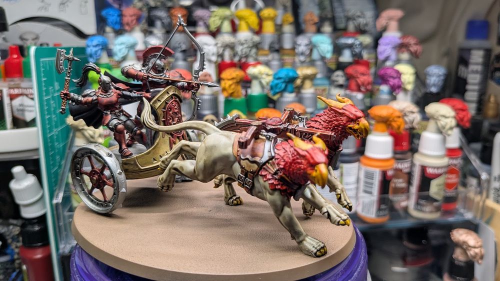 A war chariot with an axeman driver, a greatbow warrior and 2 gryph-hounds