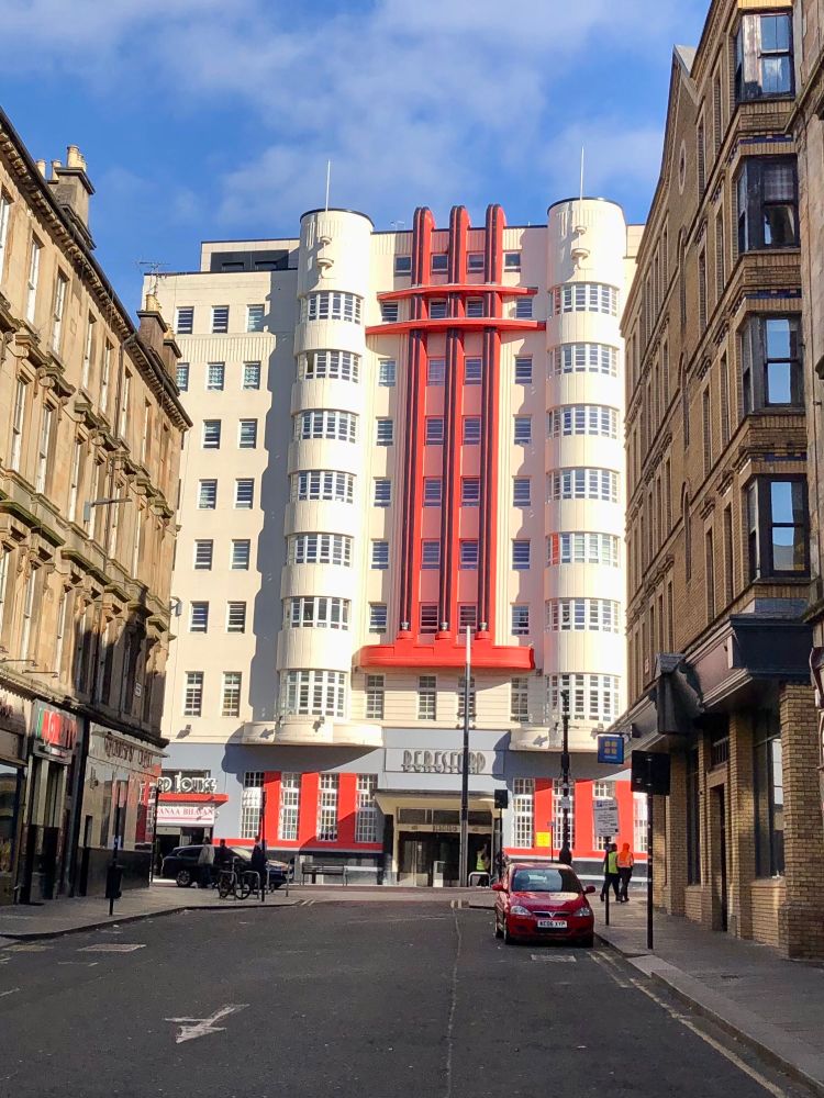 Cream and red Beresford building against blue sky from side street
