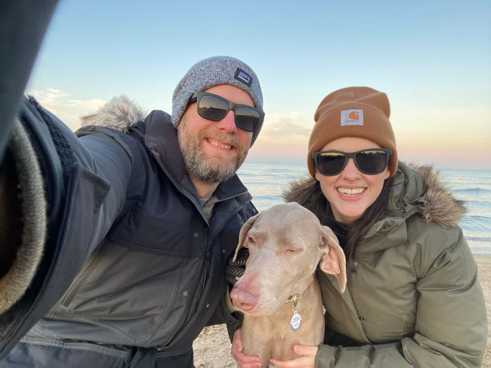 A dog reluctantly poses for a selfie with her owners. 