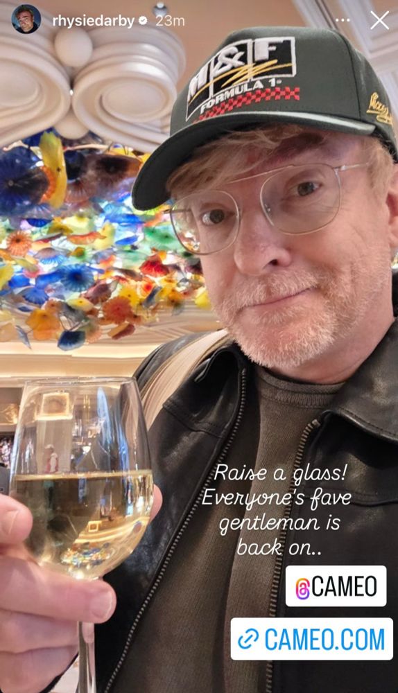 Screenshot of Rhys holding a glass of wine with a small smile and the text “Raise a glass!
Everyone's fave gentleman is back on..
©CAMEO”