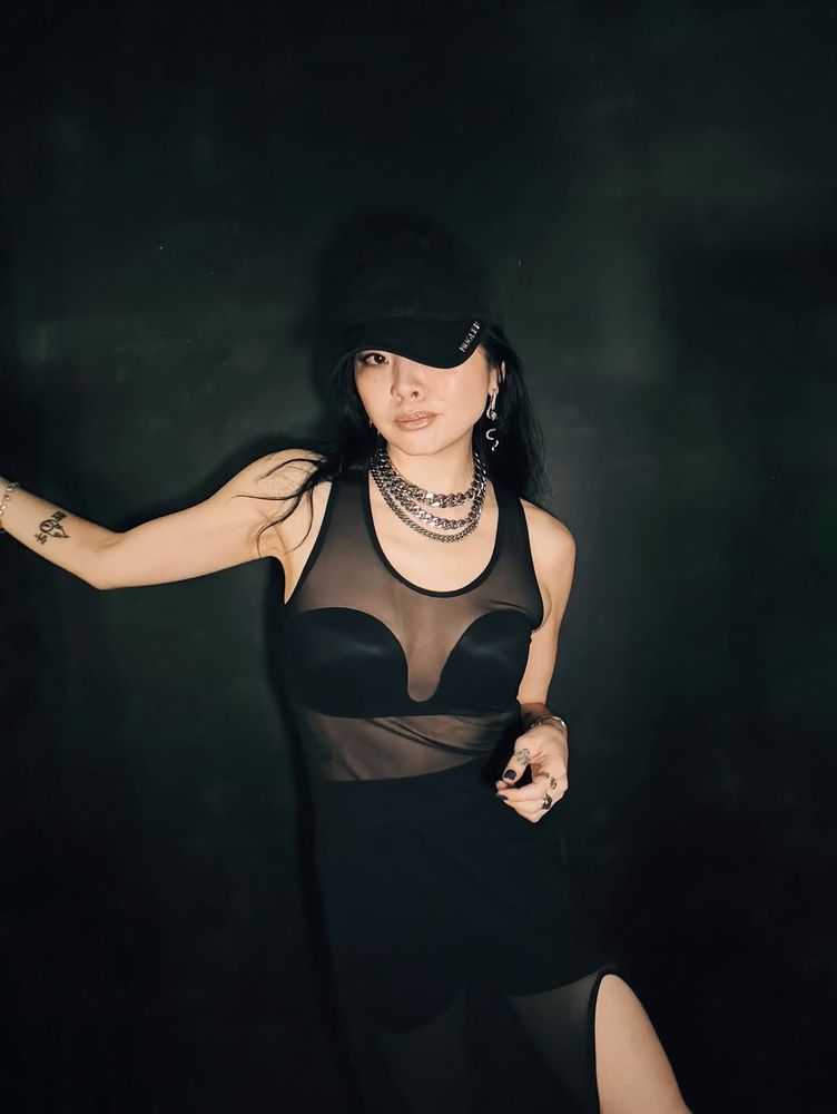 Ruibo Qian in a black cap and sheer top and black skirt from IG