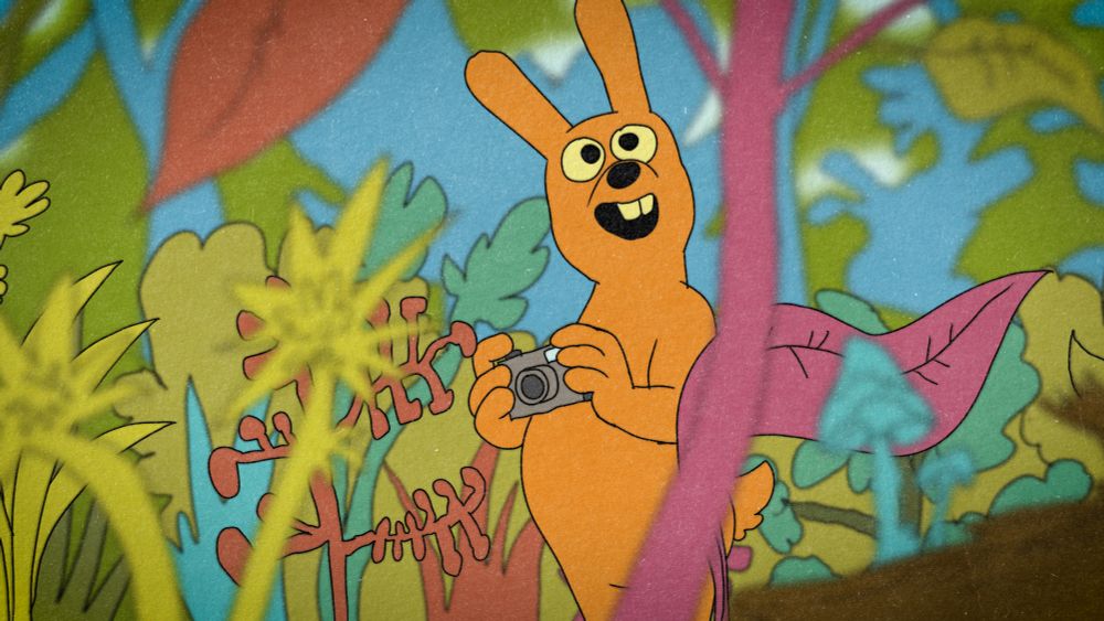 Orange bunny man holds his camera and looks about in wonderment at the natural splendor of the native flora of the Wissahickon Valley in Philadelphia.