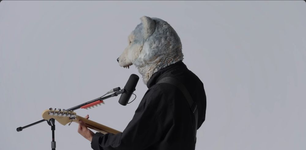 image du clip man with a mission millet 
le chanteur et guitarist de dos profil avec un costume de loup il manque la machoire du bas ( pour laisser la bouche du chanteur libre )