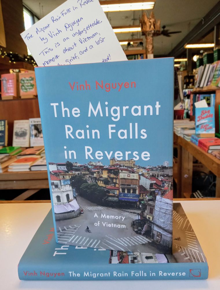 A Copy of The Migrant Rain Falls in Reverse on the counter at Island Books