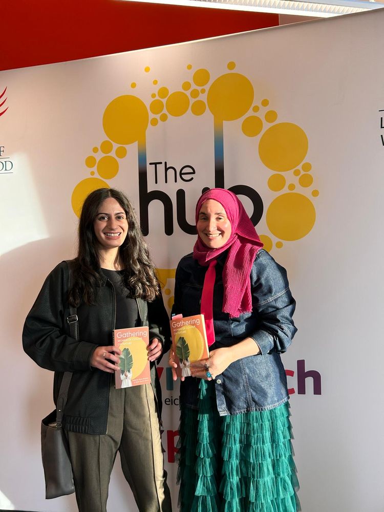 Durre and Hanan, standing next to Hub banner