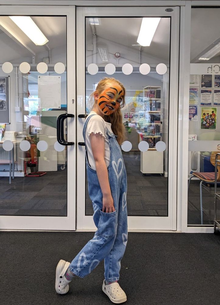 Smiling girl with tiger facepaint, standing