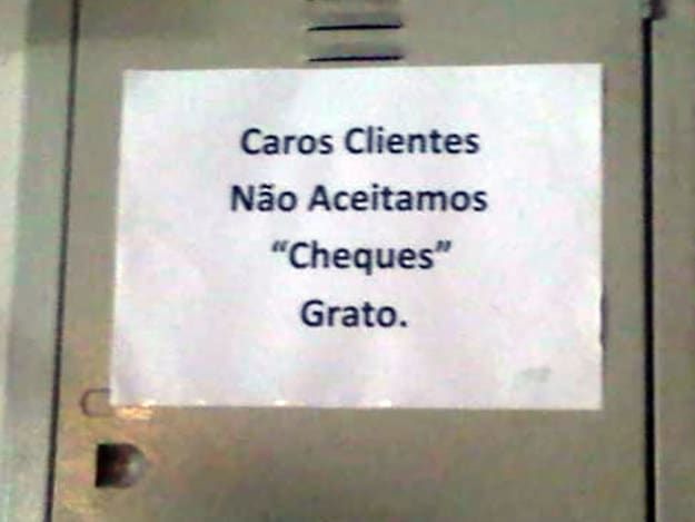 Folha colada numa porta de armário metálico: Carlos Clientes Não Aceitamos "Cheques" Grato.