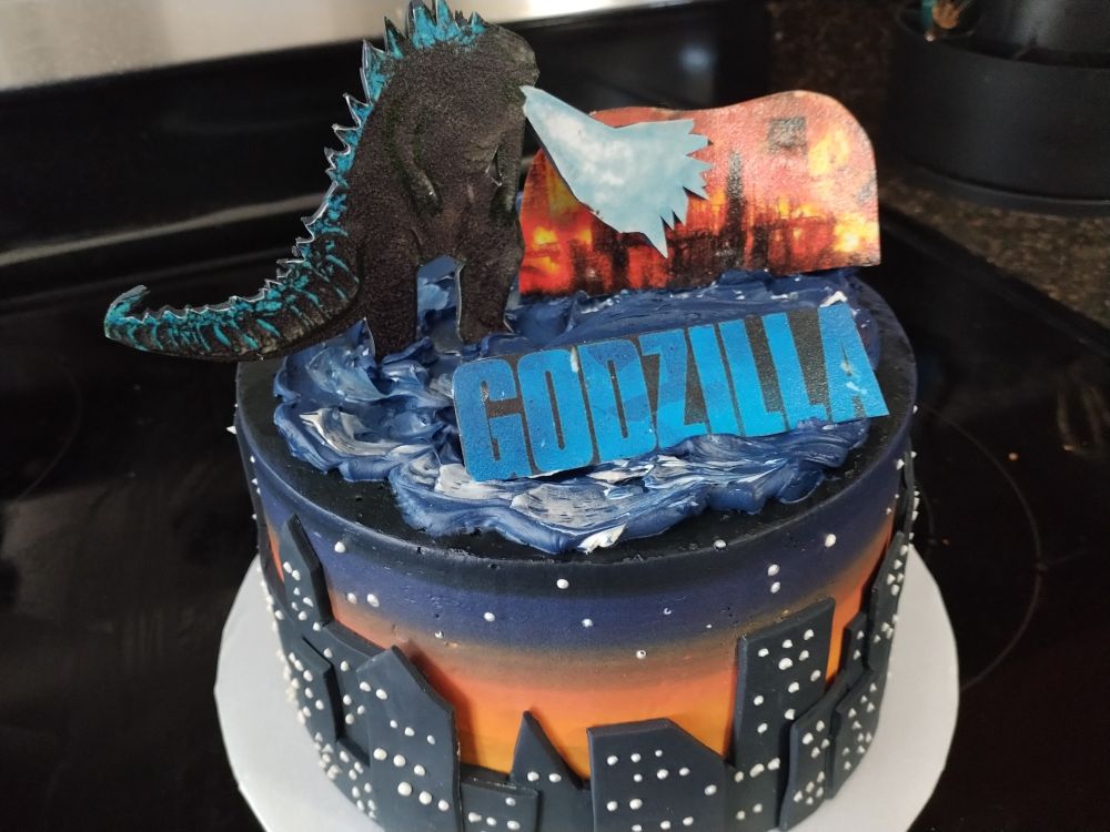 Godzilla custom cake with Godzilla using his heat breath to destroy a city.
