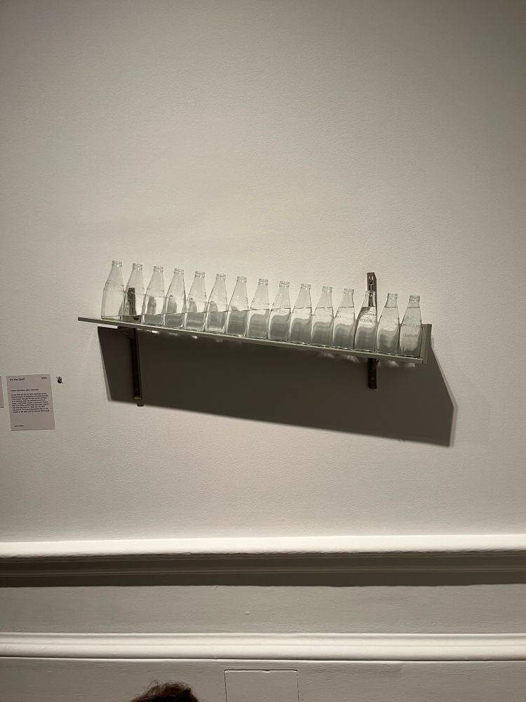 Milk bottles on a tilt with water in them filled to create a straight line