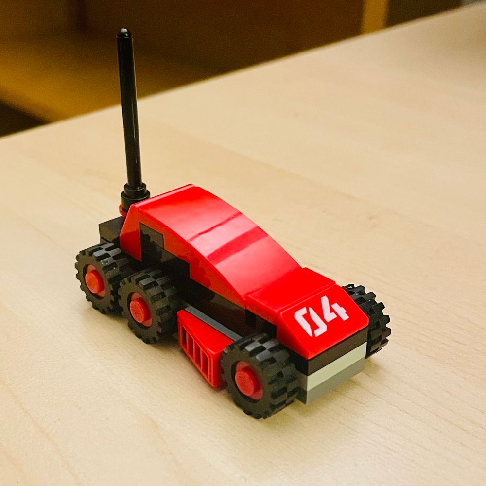 A red and black six wheel autonomous rover.